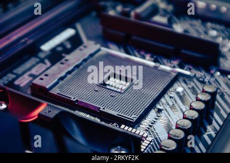 Socket CPU AM4 sulla scheda madre di un potente PC moderno. Primo piano dei componenti del chipset hardware del computer in luce blu. Background tecnico-elettronico Foto Stock