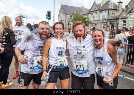 Concorrenti dopo aver terminato gli Scottish Coal Carating Championships. Gli uomini trasportano sacchi di carbone da 50 kg e le donne trasportano sacchi da 25 kg su un percorso di 1 km per le strade di Kelty in Fife Foto Stock