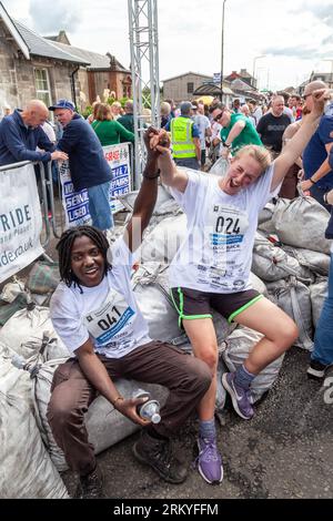 Concorrenti dopo aver terminato gli Scottish Coal Carating Championships. Gli uomini trasportano sacchi di carbone da 50 kg e le donne trasportano sacchi da 25 kg su un percorso di 1 km per le strade di Kelty in Fife Foto Stock