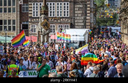 Brema, Germania. 26 agosto 2023. I partecipanti al Christopher Street Day (CSD) camminano con bandiere e striscioni attraverso la piazza del mercato, oltre il Roland. La polizia prevedeva da 10.000 a 12.000 persone per la processione di dimostrazione attraverso la città anseatica. Crediti: Focke Strangmann/dpa/Alamy Live News Foto Stock