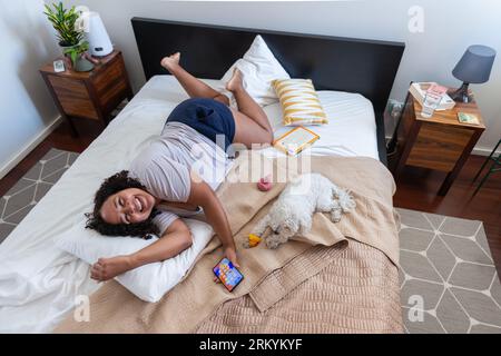 Donna a letto con cane Foto Stock