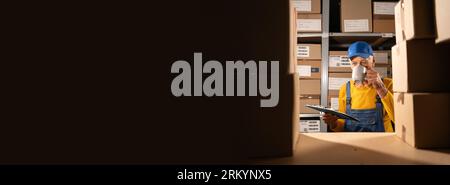 Anziano operaio di magazzino che beve tè che fa un inventario delle merci usando gli appunti per controllare Foto Stock