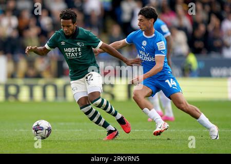 Korey Smith (a sinistra) del Derby County e Joel Randall del Peterborough United si battono per il pallone durante la partita della Sky Bet League One al Weston Homes Stadium di Peterborough. Data foto: Sabato 26 agosto 2023. Foto Stock