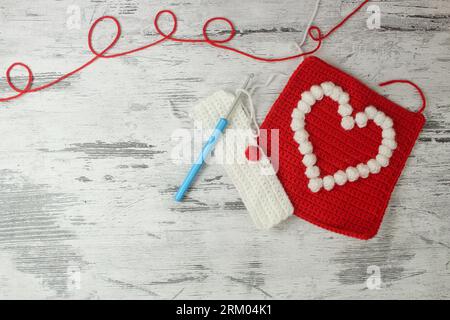 Motivi a forma di popcorn a forma di cuore per coperte a uncinetto in rosso e bianco con spazio per il testo. Vista dall'alto. Foto Stock