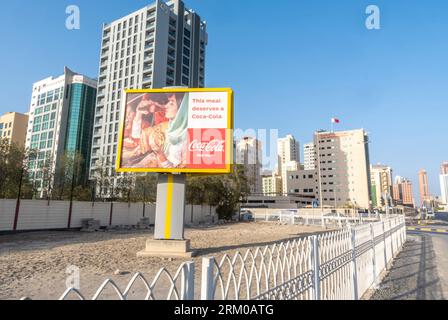 Coca-Cola: Pubblicità pubblicitaria su muro all'aperto con vera magia sulla strada a Manama, Bahrain. Una donna araba che beve pubblicità Coca-Cola Foto Stock