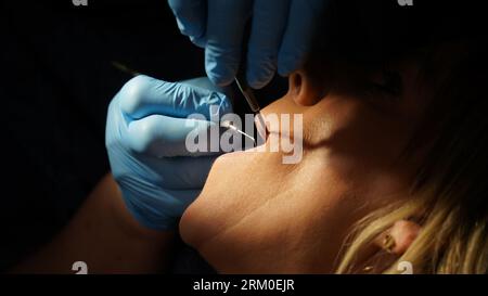 trattamento dentale. Donna che si pulisce i denti e che si sta curando l'impianto Foto Stock