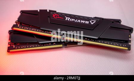 Kiev, Ucraina - 5 gennaio 2022: Moduli di memoria DRAM DDR4 G.Skill Ripjaws serie V con luce rossa. Primo piano del chip RAM del computer su bianco. Memoria desktop Foto Stock