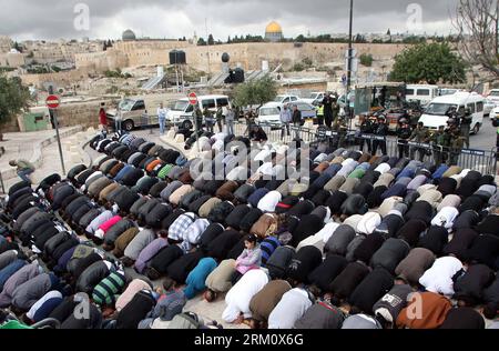 Bildnummer: 59477598  Datum: 05.04.2013  Copyright: imago/Xinhua (130405) -- JERUSALEM, April 5, 2013(Xinhua) -- Israeli border police officers stand guard as Palestinians pray on a street in the East Jerusalem neighbourhood of Ras al-Amud, on April 5, 2013. Israeli forces sealed off the West Bank and massed riot squads around Jerusalem s Old City. Israel said Thursday that Hamas was responsible for shelling fire from Gaza into southern Israel, but do not see another military operation soon. (Xinhua/Muammar Awad) (zf) MIDEAST-JERUSALEM-PRAYER PUBLICATIONxNOTxINxCHN Gesellschaft xas x2x 2013 qu Stock Photo