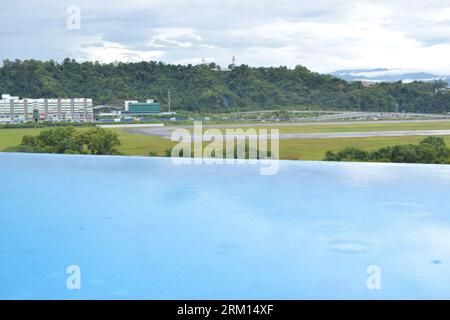 Vista della piscina dell'hotel sui binari aeroportuali di KK Malaysia. Foto Stock