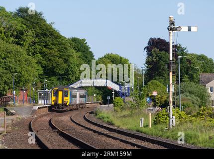 Treno velocista Northern Rail classe 156 alla stazione ferroviaria di Arnside con segnale ferroviario a semaforo Foto Stock