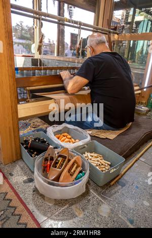 Un maestro di tessitura gestisce la macchina tessile della tessitura presso la fabbrica e officina di tessitura Naseej, Bani Jamra Village in Bahrain Bahrain Foto Stock