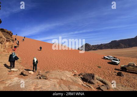 Turisti presso al Ramal Red Sand Dune, Wadi Rum, sito patrimonio dell'umanità dell'UNESCO, Giordania, Medio Oriente Foto Stock