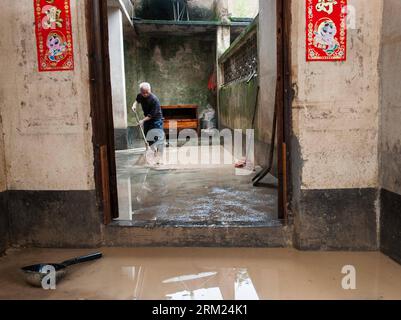 Bildnummer: 59691984 Datum: 24.05.2013 Copyright: imago/Xinhua (130524) -- JIAOLING, 24 maggio 2013 (Xinhua) -- Zhong Yongxiang, 59, pulisce la sua casa allagata nel villaggio Legan della contea di Jiaoling, città di Meizhou, provincia del Guangdong, 23 maggio 2013. Zhong ha due figli, uno soffre di paralisi cerebrale e un altro frequenta la scuola fuori dalla loro città natale, il che rende la vita più difficile per Zhong dopo il temporale che ha colpito la provincia del Guangdong il 18 maggio. Con i giovani che frequentano la scuola o lavorano al di fuori della loro città natale, i membri della famiglia rimasti stanno diventando ancora più vulnerabili a poppa Foto Stock