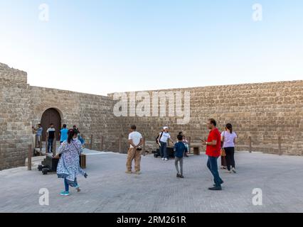 Turisti a Qall'at al-Bahrain - forte del Bahrain, fortezza di al Qala, Bahrain Foto Stock