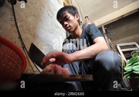 Bildnummer: 59709209  Datum: 26.05.2013  Copyright: imago/Xinhua SHANGLIN, May 26, 2013 - Lan Chuan prepares the lunch at Fozi Village in Shanglin County of Nanning City, capital of southwest China s Guangxi Zhuang Autonomous Region, May 26, 2013. Lan, a 15-year-old middle school student, lives with his paralyzed father on fixing farming machines. Without the care of mother who left the family when he was three years old, Lan takes care of his father and supports his family by aiding him with the fixing work. His story has moved many in the region, which also brought him the title of juvenile Stock Photo