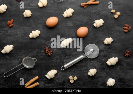 Composition with raw croissants, ingredients and utensils on dark background Stock Photo