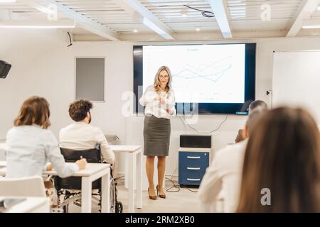 Gli impiegati che utilizzano presentazioni video per comunicare informazioni a colleghi e clienti in modo più coinvolgente e visivamente accattivante Foto Stock