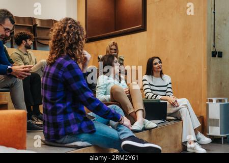 I dipendenti i colleghi discutono del brainstorming di collaborazione durante la riunione del team dell'ufficio. Felici uomini d'affari multietnici lavorano insieme, discutendo di nuove idee di business Foto Stock