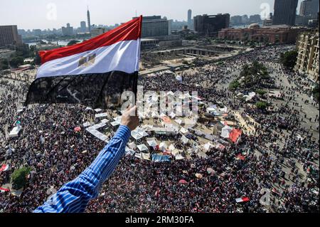 Bildnummer: 59922688  Datum: 30.06.2013  Copyright: imago/Xinhua (130630) -- CAIRO, June 30, 2013 (Xinhua) -- A man waves an Egyptian national flag during an anti-President Mohamed Morsi rally on the roof of a building near Tahrir Square in Cairo, capital of Egypt, on June 30, 2013. Millions of Egyptians have been flocking Sunday to major squares across the country to join anti- and pro-President Mohamed Morsi demonstrations. (Xinhua/Li Muzi) (syq) EGYPT-CAIRO-RALLIES PUBLICATIONxNOTxINxCHN Gesellschaft Politik Protest Demo Jahrestag Revolution Symbolfoto x2x xst premiumd Highlight 2013 quer o Stock Photo