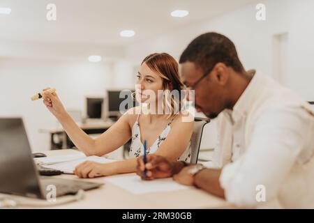 Analizzando i dati aziendali, diversi team collaborano alla pianificazione strategica, all'innovazione e al lavoro di squadra. Lavorando in modo efficiente in un ufficio, puntano a gro Foto Stock