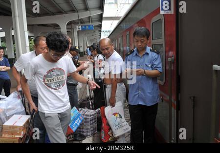 Bildnummer: 59930881 Datum: 02.07.2013 Copyright: imago/Xinhua (130702) -- HAIKOU, 2 luglio 2013 (Xinhua) -- i passeggeri hanno i biglietti controllati per il primo treno diretto da Haikou a Harbin presso la stazione ferroviaria di Haikou a Haikou, capitale della provincia di Hainan della Cina meridionale, 2 luglio 2013. Il treno K1122/3 dal sud della Cina di Haikou al nord-est della Cina di Heilongjiang ha lasciato Haikou martedì, un giorno dopo la data di partenza originale a causa della tempesta tropicale Rumbia. Il treno, che percorre 4.458 chilometri per 65 ore, ha collegato la capitale più meridionale della Cina, Haikou, della provincia di Hainan Foto Stock