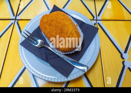 Napoli, città metropolitana di Napoli, Italia, Una crocchetta su un piatto bianco. Foto Stock