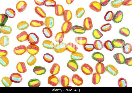 Caramelle gommose colorate versate su sfondo bianco Foto Stock