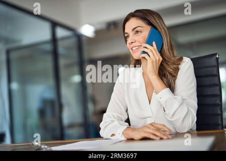 Dirigente di mezza età sicura che effettua telefonate in ufficio. Foto Stock