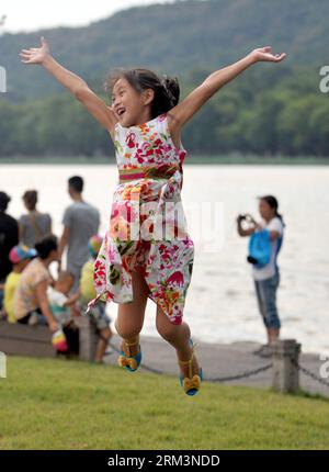 Bildnummer: 60260022 Datum: 31.07.2013 Copyright: imago/Xinhua (130731) -- HANGZHOU, 31 luglio 2013 (Xinhua) -- Una bambina si diverte sul Baidi Causeway presso il Lago Ovest di Hangzhou, capitale della provincia dello Zhejiang della Cina orientale, 31 luglio 2013. Una doccia di tuoni il mercoledì ha portato fresco a Hangzhou, una città che ha vissuto sei giorni di temperature superiori ai 40 gradi Celsius dal 24 luglio. (Xinhua/Wang Dingchang)(wjq) CHINA-ZHEJIANG-HANGZHOU-THUNDER SHOWER (CN) PUBLICATIONxNOTxINxCHN Gesellschaft x2x xkg 2013 hoch premiumd o0 tipo freude Mädchen springt sprung optimistisch 60260022 da Foto Stock