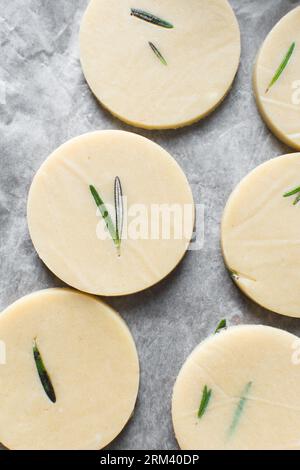 Vista dall'alto dell'impasto crudo di biscotti al rosmarino, dell'impasto di biscotti al rosmarino che sta per essere cotto, processo di preparazione dei biscotti allo zucchero al rosmarino Foto Stock