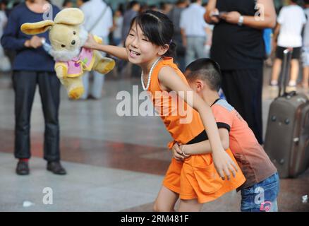 Bildnummer: 60393512  Datum: 26.08.2013  Copyright: imago/Xinhua (130826) -- CHONGQING, Aug. 26, 2013 (Xinhua) -- Zhang Lu (L), a girl from southwest China s Chongqing Municipality and studying at a primary school in south China s Guangzhou, plays with her younger brother while waiting for her train back to Guangzhou, in the Chongqing North Railway Station, Aug. 26, 2013. As the summer vacation is drawing to an end, many children of migrant workers start to return to the places where they go to school. (Xinhua/Li Jian)(wjq) CHINA-CHONGQING-MIGRANT CHILDREN (CN) PUBLICATIONxNOTxINxCHN Gesellsch Stock Photo