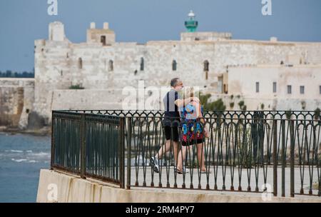 Bildnummer: 60506305 Datum: 20.09.2013 Copyright: imago/Xinhua (130920) -- SIRACUSA, 20 settembre 2013 (Xinhua) -- una coppia gode della vista sul mare di Ortigia, il centro storico di Siracusa in Sicilia, Italia, 5 settembre 2013. Situata nell'angolo sud-est dell'isola di Sicilia, Siracusa è una città storica in Italia. La città di 2.700 anni, fondata nel 734 o 733 a.C. dai coloni greci di Corinto e Tenea, giocò un ruolo chiave nei tempi antichi, quando era una delle maggiori potenze del mondo mediterraneo. Una volta descritta da Cicerone, rinomato filosofo e oratore romano, come la più grande città greca e la più grande Foto Stock