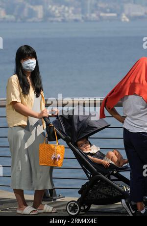 Vancouver, Canada. 26 agosto 2023. Un cittadino che indossa una maschera facciale è visto sul lungomare in Haze nel centro di Vancouver, British Columbia, Canada, 26 agosto 2023. La Metro Vancouver ha continuato un avviso sulla qualità dell'aria per la regione metropolitana di Vancouver sabato a causa dell'alta concentrazione di particolato fine causata dal fumo di incendi che si diffondono in tutta la Columbia Britannica. Crediti: Liang Sen/Xinhua/Alamy Live News Foto Stock