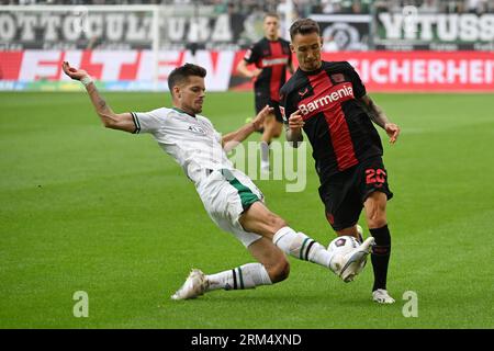 Moenchengladbach, Germania. 26 agosto 2023. Julian Weigl (L) del Borussia Moenchengladbach vies con Alejandro Grimaldo del Bayer 04 Leverkusen durante la loro partita di secondo turno in Bundesliga a Moenchengladbach, Germania, 26 agosto 2023. Crediti: Ulrich Hufnagel/Xinhua/Alamy Live News Foto Stock