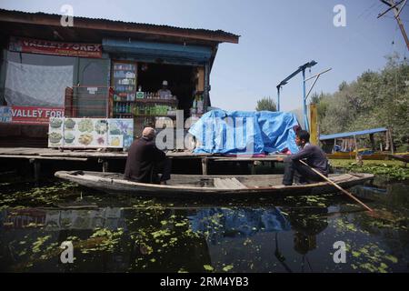 Bildnummer: 60534810 Datum: 27.09.2013 Copyright: imago/Xinhua (130927) -- SRINAGAR, 27 settembre 2013 (Xinhua) -- sedersi su una barca di fronte a un negozio sul lago dal a Srinagar, la capitale estiva del Kashmir controllato dagli indiani, 27 settembre 2013. Il lago dal, il lago più grande e la destinazione turistica più popolare di Srinagar, è il luogo in cui vivono molti locali. Vivono nelle case costruite sulle isole e nelle case galleggianti sull'acqua del lago e prendono barche per la commutazione giornaliera. Negozi, case e giardini punteggiano il lago. Grazie al clima mite e al paesaggio, il turismo è diventato la fonte principale Foto Stock