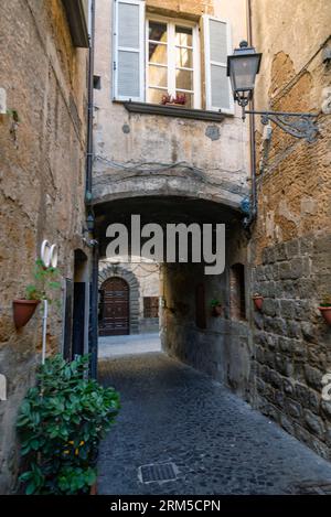 Todi, Umbria, Italia: Pittoresco e antico vicolo con arco nel centro storico Foto Stock