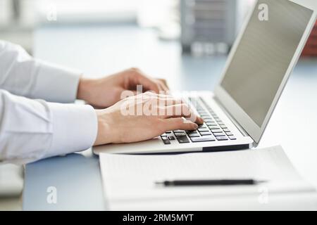 A disposizione di un ingegnere responsabile della gestione delle costruzioni che organizza i materiali su un computer portatile Foto Stock