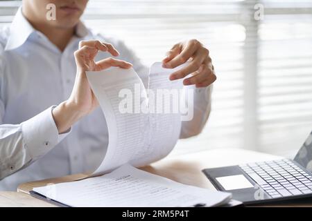 Un uomo d'affari asiatico che rompe il contratto Foto Stock