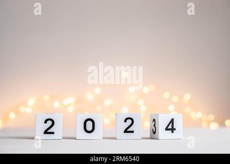 Capodanno 2024 in arrivo. Numeri su cubi di blocco in legno che ruotano da 2023 a 2024 Foto Stock