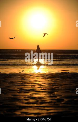 Bildnummer: 60831514 Datum: 14.12.2013 Copyright: imago/Xinhua una madre e suo figlio si trovano su una spiaggia per vedere il tramonto a Karachi, Pakistan, il 14 dicembre 2013. (Xinhua/Huang Zongzhi) PAKISTAN-KARACHI-SUNSET PUBLICATIONxNOTxINxCHN xcb x0x 2013 canali Foto Stock