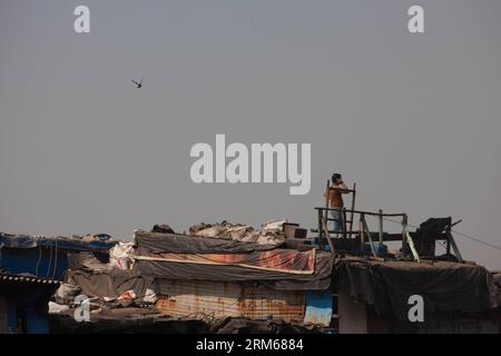 (131218) -- MUMBAI, 18 dicembre 2013 (Xinhua) -- Un uomo fa una telefonata su un tetto nella zona slum di Mumbai, India, 18 dicembre 2013. (Xinhua/Zheng Huansong) INDIA-MUMBAI-SLUM AREA-LIFE PUBLICATIONxNOTxINxCHN Mumbai DEC 18 2013 XINHUA un uomo effettua una chiamata telefonica SU un tetto nella zona Slum di Mumbai India DEC 18 2013 XINHUA Zheng Huansong India Mumbai Slum area Life PUBLICATIONXNOTxINxCHN Foto Stock