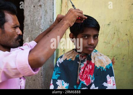 (131218) -- MUMBAI, 18 dicembre 2013 (Xinhua) -- Un barbiere taglia i capelli per un cliente nella zona slum di Mumbai, India, 18 dicembre 2013. (Xinhua/Zheng Huansong) INDIA-MUMBAI-SLUM AREA-LIFE PUBLICATIONxNOTxINxCHN Mumbai DEC 18 2013 XINHUA a a Barber taglia i capelli per un cliente nella Slum area di Mumbai India DEC 18 2013 XINHUA Zheng Huansong India Mumbai Slum area Life PUBLICATIONXNOTxINCHN Foto Stock