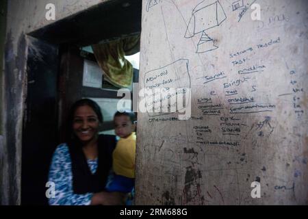 (131218) -- MUMBAI, 18 dicembre 2013 (Xinhua) -- Una donna tiene il suo bambino a casa nella zona slum di Mumbai, India, 18 dicembre 2013. (Xinhua/Zheng Huansong) INDIA-MUMBAI-SLUM AREA-LIFE PUBLICATIONxNOTxINxCHN Mumbai DEC 18 2013 XINHUA una donna tiene il suo bambino A casa nella zona Slum di Mumbai India DEC 18 2013 XINHUA Zheng Huansong India Mumbai Slum area Life PUBLICATIONXNOTxINxCHN Foto Stock