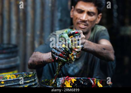 (131218) -- MUMBAI, 18 dicembre 2013 (Xinhua) -- Un uomo pulisce la vernice sui secchi nella zona slum di Mumbai, India, 18 dicembre 2013. (Xinhua/Zheng Huansong) INDIA-MUMBAI-SLUM AREA-LIFE PUBLICATIONxNOTxINxCHN Mumbai DEC 18 2013 XINHUA a Man pulisce la vernice SUI secchi nella Slum area di Mumbai India DEC 18 2013 XINHUA Zheng Huansong India Mumbai Slum area Life PUBLICATIONXNOTxINCHN Foto Stock