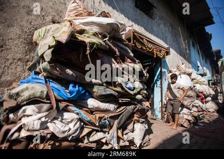 (131218) -- MUMBAI, 18 dicembre 2013 (Xinhua) -- Un uomo si trova all'esterno di un negozio di spazzatura nella zona slum di Mumbai, India, 18 dicembre 2013. (Xinhua/Zheng Huansong) INDIA-MUMBAI-SLUM AREA-LIFE PUBLICATIONxNOTxINxCHN Mumbai DEC 18 2013 XINHUA un uomo si trova fuori da un negozio di immondizia nella Slum area di Mumbai India DEC 18 2013 XINHUA Zheng Huansong India Mumbai Slum area Life PUBLICATIONXNOTXINCHN Foto Stock