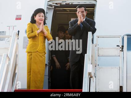 (131226) -- PHNOM PENH, 26 dicembre 2013 (Xinhua) -- il primo ministro cambogiano Hun Sen (R) e sua moglie Bun Rany gesture mentre partono per una visita in Vietnam a Phnom Penh, Cambogia, 26 dicembre 2013. (Xinhua/Sovannara) CAMBOGIA-PHNOM PENH-PM PUBLICATIONxNOTxINxCHN Foto Stock