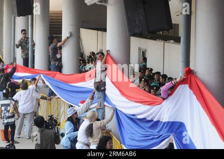 (131225) -- BANGKOK, 25 dicembre 2013 (Xinhua) -- i manifestanti anti anti-governativi thailandesi appendono una bandiera mentre tentano di interrompere la registrazione elettorale allo stadio giovanile Thai-Japan a Bangkok, Thailandia, 25 dicembre 2013. Il Premier thailandese Yingluck Shinawatra ha dichiarato mercoledì che presto istituirà un consiglio per le riforme del paese che inizierà a lavorare parallelamente alle prossime elezioni del 2 febbraio. (Rachen Sageamsak) (djj) THAILANDIA-BANGKOK-PROTESTA PUBLICATIONxNOTxINxCHN Bangkok DEC 25 2013 i manifestanti anti-governo thailandesi inclinano una bandiera mentre interrompono la registrazione ELETTORALE AL Thai Japa Foto Stock