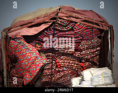 (140104) -- KABUL, 4 gennaio 2014 (Xinhua) -- un uomo afghano scarica trapunte donate dal governo tedesco a Kabul, Afghanistan, il 4 gennaio 2014. Centinaia di famiglie sfollate hanno ricevuto aiuti invernali sabato. (Xinhua/Ahmad Massoud) AFGHANISTAN-KABUL-WINTER RELIEF PUBLICATIONxNOTxINxCHN Kabul 4 gennaio 2014 XINHUA all'afghano SCARICA TRAPUNTE donate dal governo tedesco a Kabul Afghanistan IL 4 gennaio 2014 centinaia di famiglie sfollate hanno ricevuto merci di soccorso invernale sabato XINHUA Ahmad Massoud Afghanistan Kabul Winter Relief PUBLICATIONXNOTXINXCHN Foto Stock