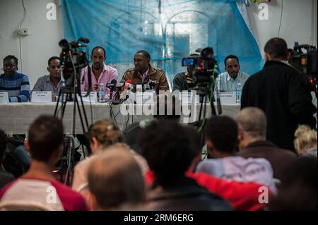 (140108) -- TEL AVIV, (Xinhua) -- Moussa Abdoulaye (4th L), un richiedente asilo del Darfur, si rivolge a una conferenza stampa a Tel Aviv, Israele, il 7 gennaio 2014. I richiedenti asilo in Israele hanno dichiarato che continueranno a scioperare fino a nuovo avviso, mentre la loro lotta per i diritti dei rifugiati entrerà nel suo terzo giorno, i rappresentanti della comunità hanno dichiarato martedì in una conferenza stampa a Tel Aviv. Decine di migliaia di richiedenti asilo sono in sciopero da domenica. Sono scesi per le strade di Tel Aviv e hanno marciato verso le ambasciate statunitensi ed europee in Israele in un appello per la pressione internazionale per annullare l'Anti-Israele Foto Stock