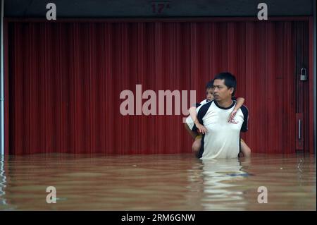 (140113) -- GIACARTA, 13 gennaio 2014 (Xinhua) -- Un uomo porta il suo bambino in acqua alluvionale a Giacarta, Indonesia, 13 gennaio 2013. La capitale indonesiana Giacarta sta prendendo precauzioni per garantire la sicurezza delle persone da possibili inondazioni più grandi, poiché finora oltre 5.000 persone sono state sfollate dalle acque, ha detto un funzionario qui lunedì. (Xinhua/veri Sanovri)(ctt) INDONESIA-JAKARTA-FLOOD PUBLICATIONxNOTxINxCHN Giacarta 13 gennaio 2014 XINHUA a Man trasporta il suo bambino in acqua alluvionale a Giacarta Indonesia 13 gennaio 2013 La capitale indonesiana Giacarta STA prendendo precauzioni per garantire la sicurezza delle celebrità dal poss Foto Stock